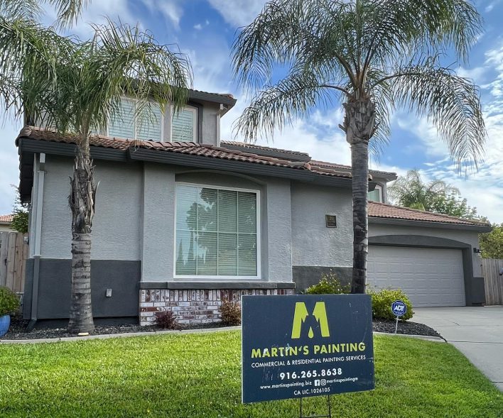House exterior with a painting service sign.